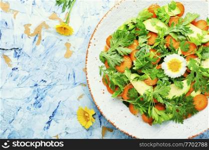 Diet salad with chrysanthemum and avocado leaves,carrots and herbs.Vegetarian salad.Copy space. Diet salad with chrysanthemum leaves and avocado