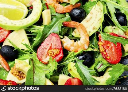 Diet salad with shrimps,strawberries,avocado and herbs.Food background. Summer salad with shrimps and strawberries,close up