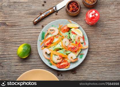 Diet salad with tomato, cucumber and shrimp.. Shrimp salad on wooden table