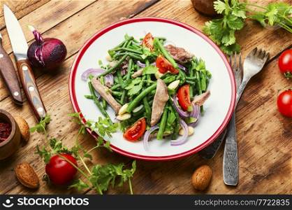 Diet salad with veal tongue, asparagus beans, tomato, herbs and almonds.. Salad with vegetables and veal tongue