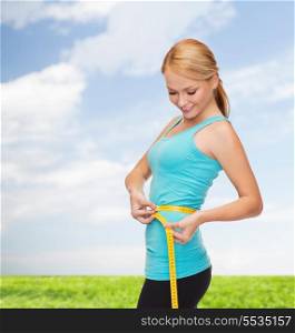 diet, sport and heath concept - beautiful sporty woman with measuring tape