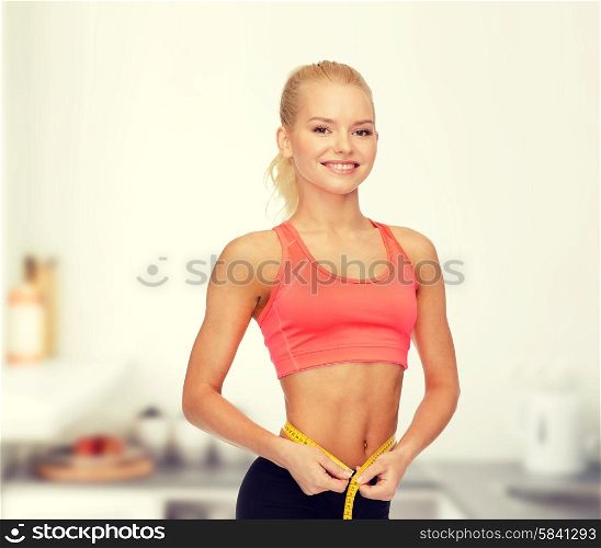 diet, sport, fitness and heath concept - smiling beautiful sporty woman with measuring tape