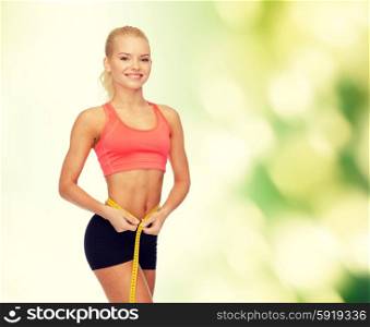 diet, sport, fitness and heath concept - smiling beautiful sporty woman with measuring tape