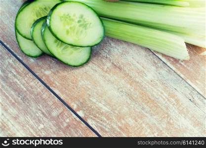 diet, vegetable food and objects concept - close up of cucumber slices and celery