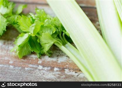 diet, vegetable food, cooking and objects concept - close up of celery stems on wooden table