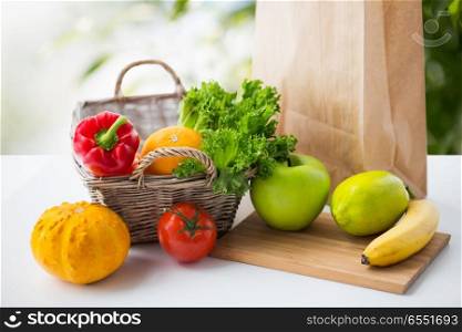 diet, vegetarian food and healthy eating concept - basket with fresh ripe juicy vegetables, greens and fruits on table over green natural background. basket of fresh vegetables and fruits on table. basket of fresh vegetables and fruits on table