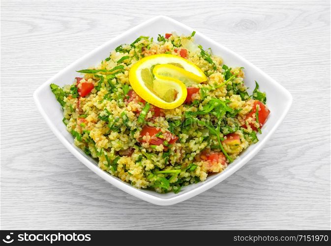 Dietary and fresh burgul salad on a light background.