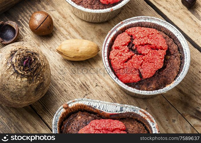 Dietary beetroot muffins with chocolate and nuts.Vegetarian food on wooden background. Closeup of a beetroot muffin