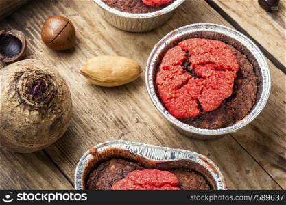Dietary beetroot muffins with chocolate and nuts.Vegetarian food on wooden background. Closeup of a beetroot muffin