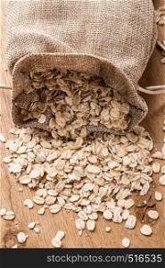 Dieting. Oat cereal in burlap sack on wooden surface. Healthy food for lowering cholesterol, protect heart.