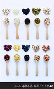 Different beans, legumes on wooden spoon on white background.