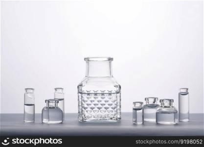 Different bottles of water on a light background. It can fit the theme of cosmetics, glass and freshness.