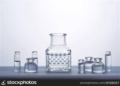 Different bottles of water on a light background. It can fit the theme of cosmetics, glass and freshness.