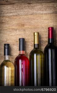 Different bottles of wine on table wooden background close-up