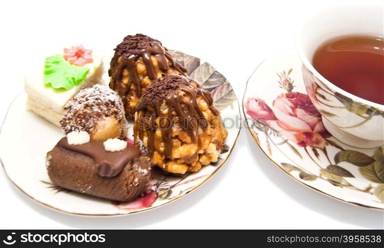 different cakes and cup of tea on white