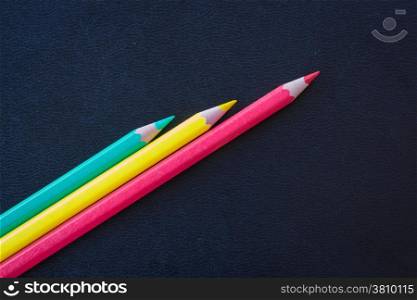 Different color pencils sharpened on dark background, stock photo