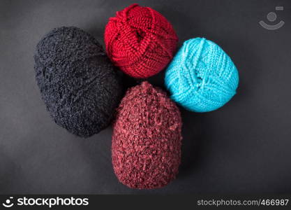 different color wool balls on dark background