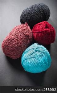 different color wool balls on dark background