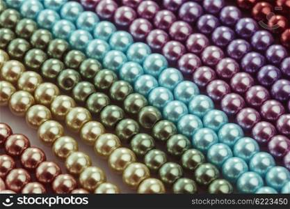 Different colors of beads necklace closeup background. Necklace palette close up