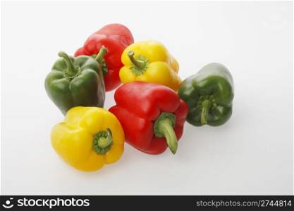 Different colors of bell peppers on light gray surface
