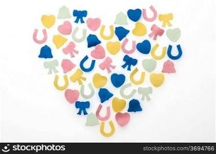 different coloured confetti in shape of heart on white background