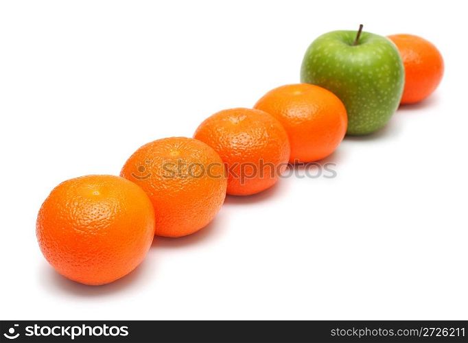 different concepts - green apple between mandarins