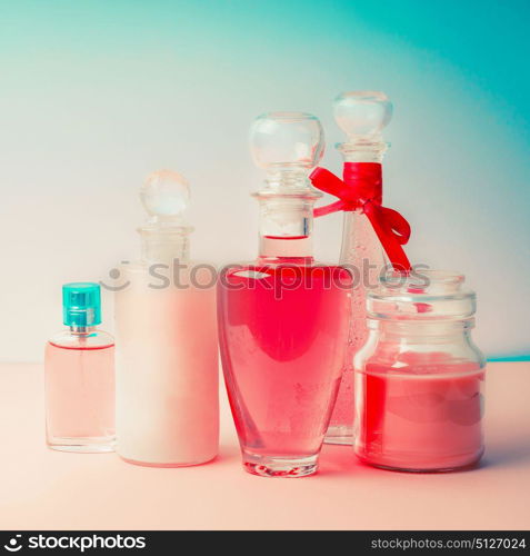 Different cosmetic bottles and products set . Cosmetic package collection for cream, soaps, foams, shampoo and perfume on Beautiful pink turquoise blue background, front view. Cosmetic shop concept