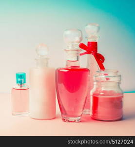 Different cosmetic bottles and products set . Cosmetic package collection for cream, soaps, foams, shampoo and perfume on Beautiful pink turquoise blue background, front view. Cosmetic shop concept