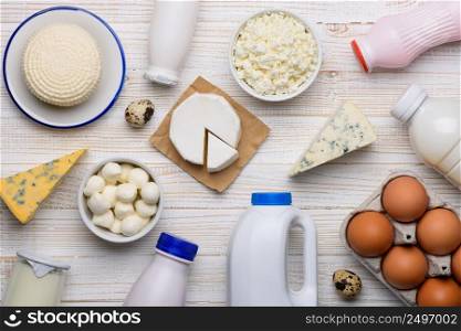 Different dairy products on white wooden table flat lay top view