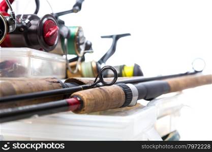 different fishing reels and rods on storage boxes with fishing baits and lures