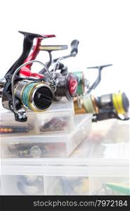 different fishing reels on storage boxes with fishing baits and lures