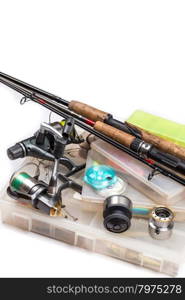 different fishing tackles - rod, reel, line and lures in box on white background