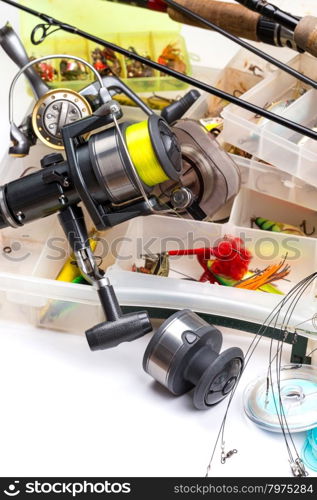 different fishing tackles - rod, reel, line and lures in box on white background