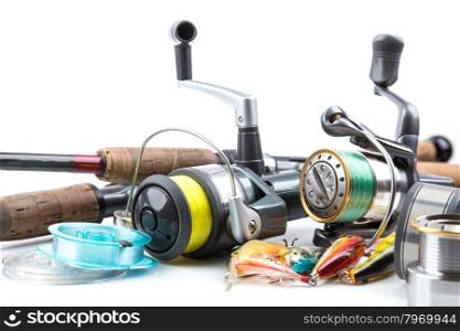 different fishing tackles - rod, reel, line and lures on white background