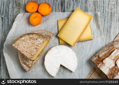 Different french cheeses with a bread and apricots