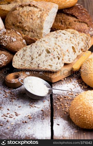 different fresh bread and buns on the wooden table 