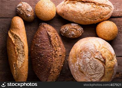 different fresh bread and buns on the wooden table
