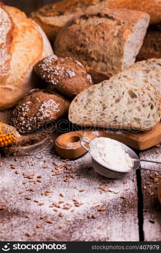 different fresh bread and buns on the wooden table