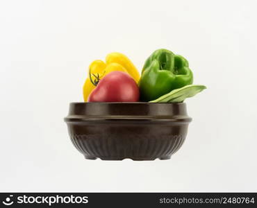 different fresh vegetables in ceramic bowl on white background in horizontal perspective, copy space and cut out. vegetables in a ceramic bowl