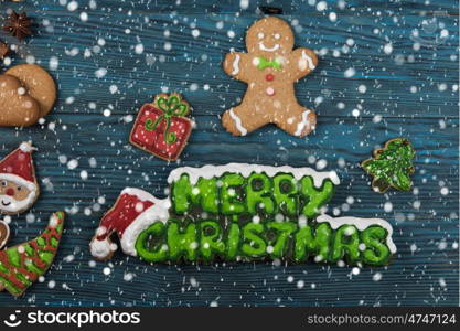 Different ginger cookies for new years and christmas on wooden background, top view