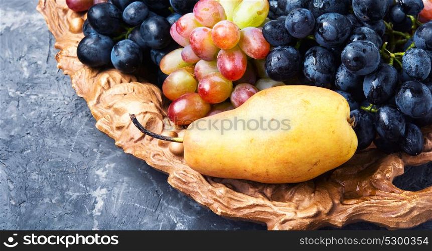 Different grapes on a tray. Bunches of fresh ripe grapes on a wooden retro tray