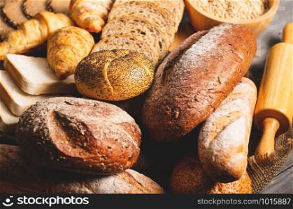 Different kinds of bread with nutrition whole grains on wooden background. Food and bakery in kitchen concept. Delicious breakfast gouemet and meal. Carbohydrate organic food cuisine homemade