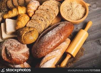 Different kinds of bread with nutrition whole grains on wooden background. Food and bakery in kitchen concept. Delicious breakfast gouemet and meal. Carbohydrate organic food cuisine homemade