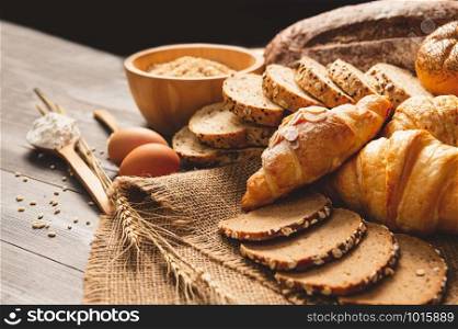 Different kinds of bread with nutrition whole grains on wooden background. Food and bakery in kitchen concept. Delicious breakfast gouemet and meal. Carbohydrate organic food cuisine homemade