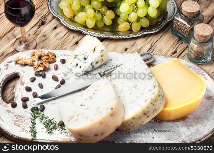 Different kinds of cheeses. aromatic Swiss cheese and a glass of grape wine