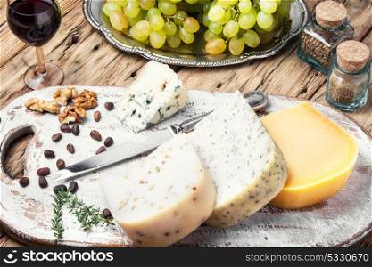 Different kinds of cheeses. aromatic Swiss cheese and a glass of grape wine