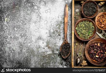 Different kinds of fragrant tea in bowls. On a rustic background.. Different kinds of fragrant tea in bowls.