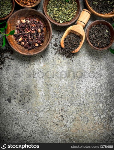 Different kinds of fragrant tea in bowls. On a rustic background.. Different kinds of fragrant tea in bowls.