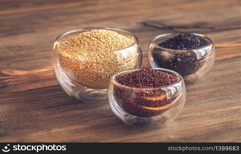 Different kinds of quinoa on wooden background