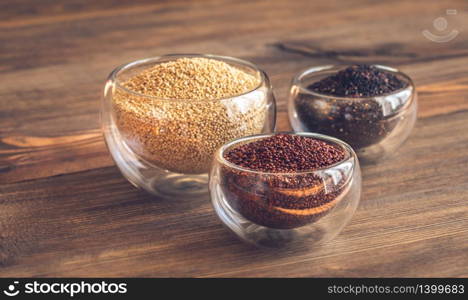 Different kinds of quinoa on wooden background